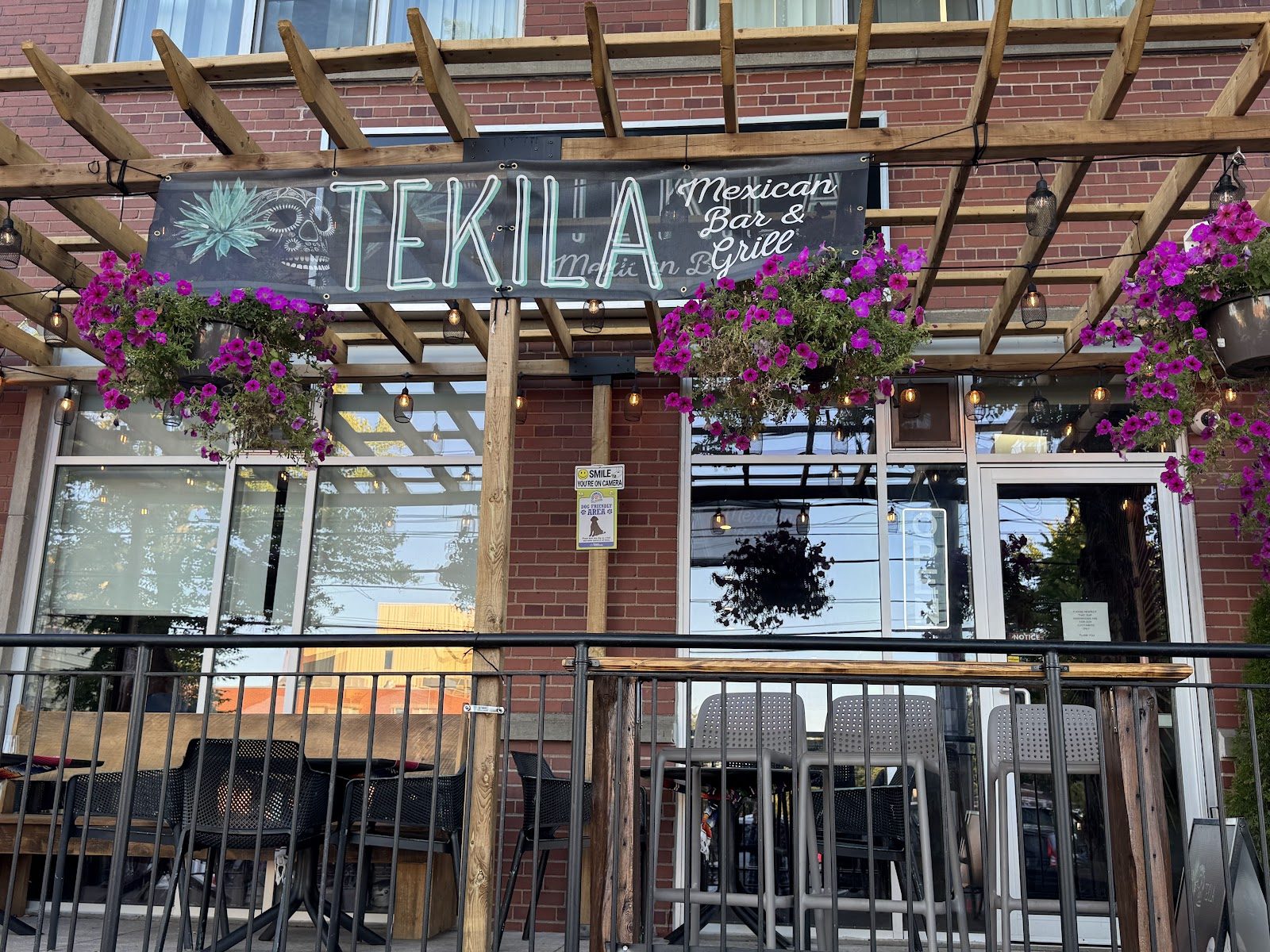 The Tekila storefront on Prince Street, with a pergola patio and hanging flower baskets