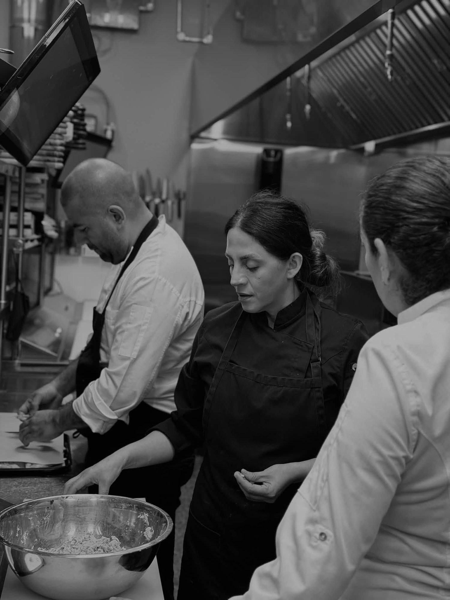 Cooks working the line during dinner service, in black and white