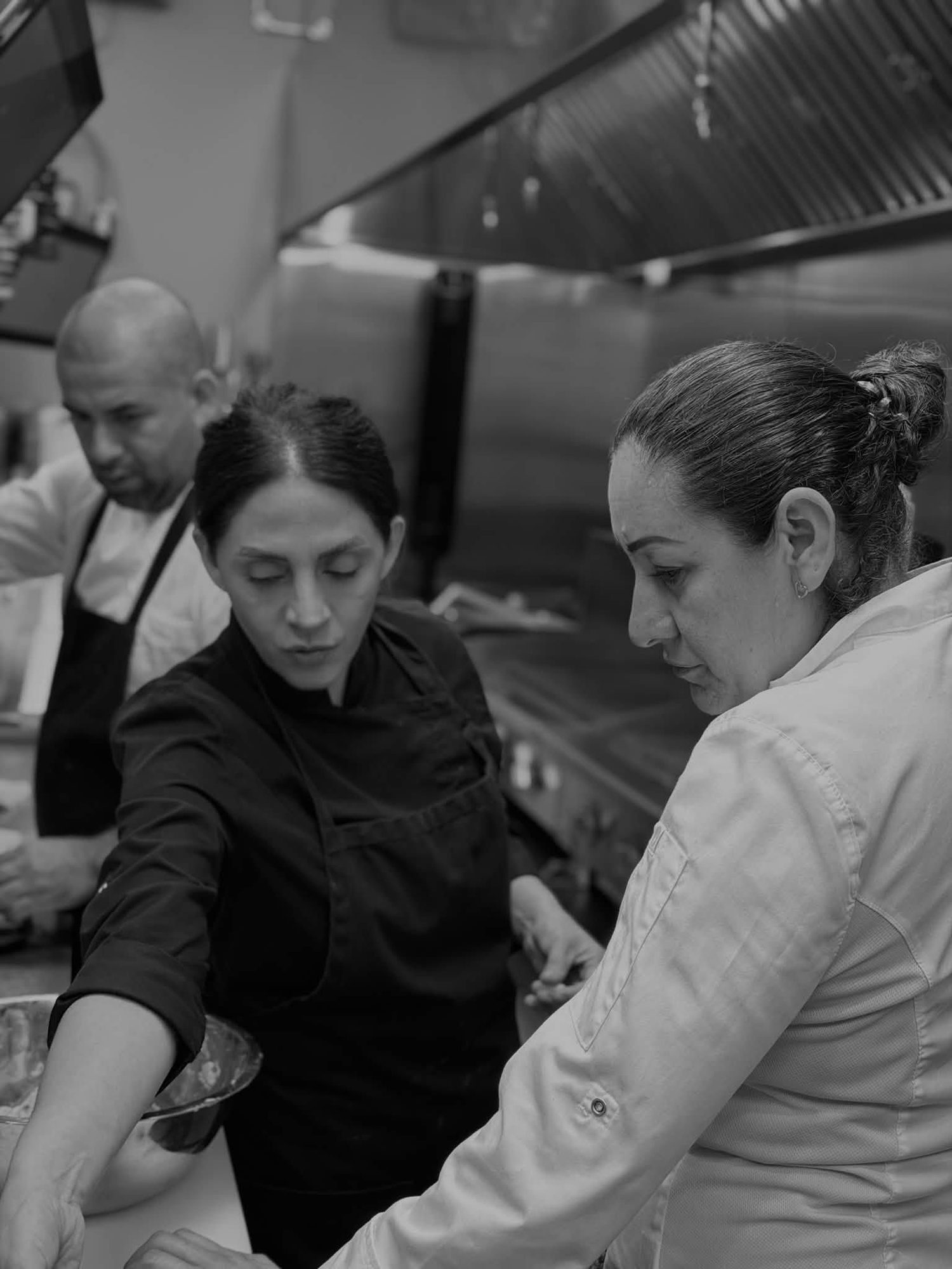 The kitchen team at work during service, in black and white