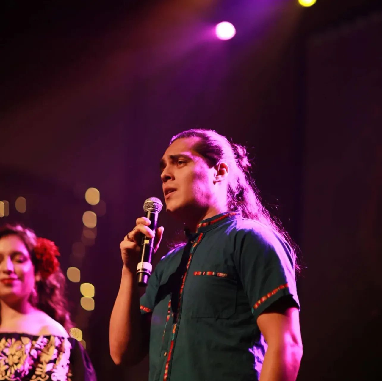 Two singers performing under stage lights at Tekila