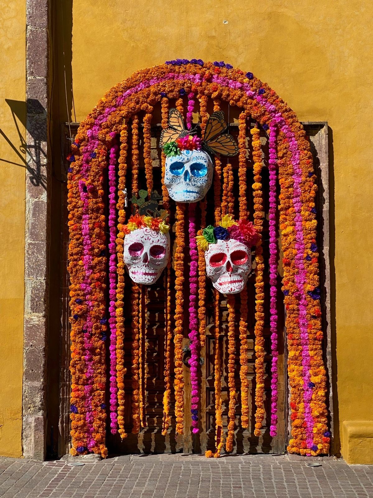 A small ofrenda with sugar skulls and marigold garlands